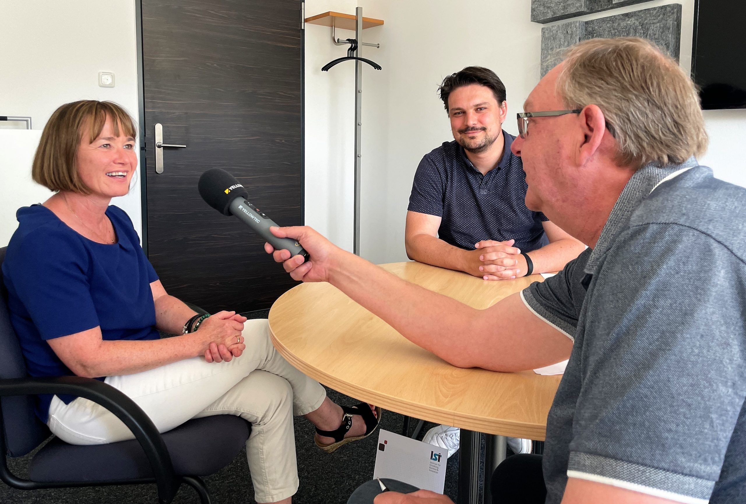 Evelyn Stegmann, Projektleiterin USIN5G beim Landkreis Harburg und Dr. Timo Maurer, Innovationsmanager bei der WLH Wirtschaftsförderung im Landkreis Harburg GmbH im Gespräch mit Wolfgang Laudan von Radio Zusa. Foto: WLH / Bianca Augustin